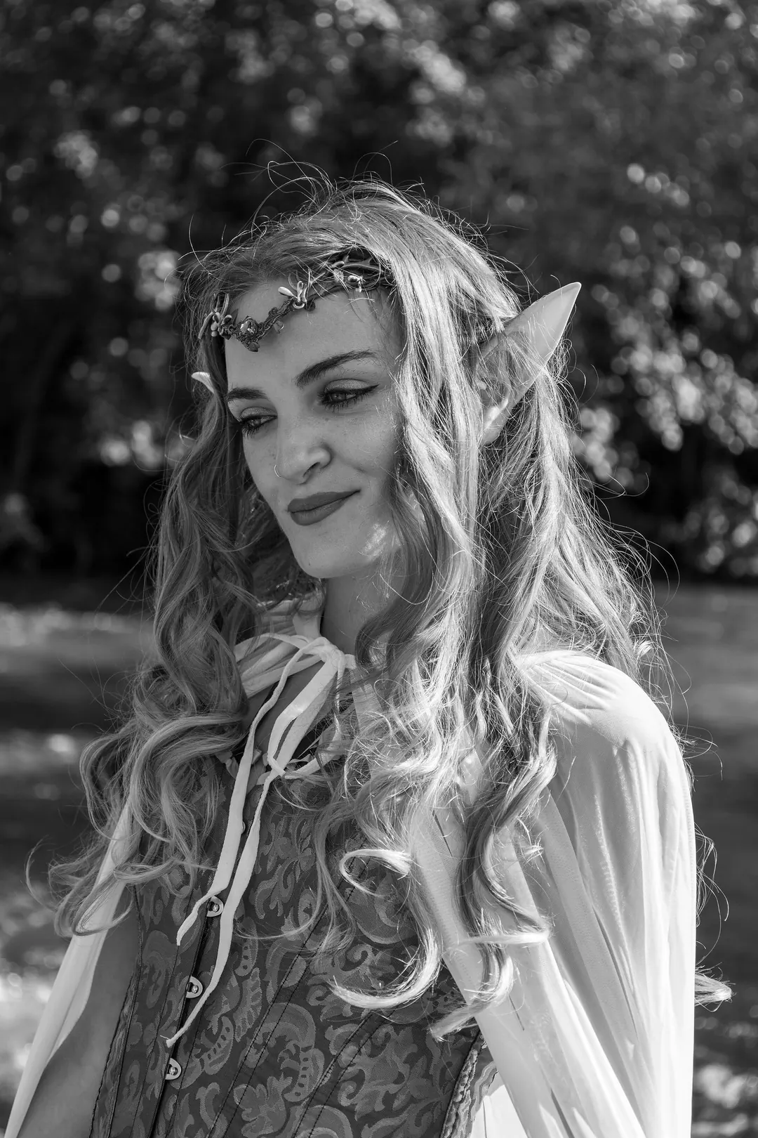 In bianco e nero, una ragazza vestita da elfo con una coroncina tra i capelli.